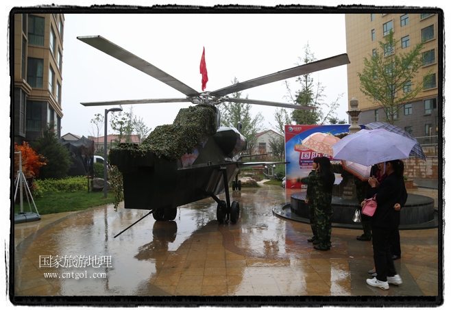 小區(qū)突然出現(xiàn)“飛機(jī)坦克”，其中殲15艦載戰(zhàn)斗機(jī)一架、99式主戰(zhàn)坦克一輛、武直-10武裝直升機(jī)一架，吸引了眾多市民雨中圍觀、合影。